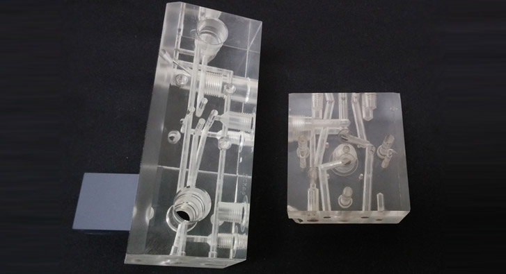 Example manifolds machined from clear acrylic in order to demonstrate internal complexities.